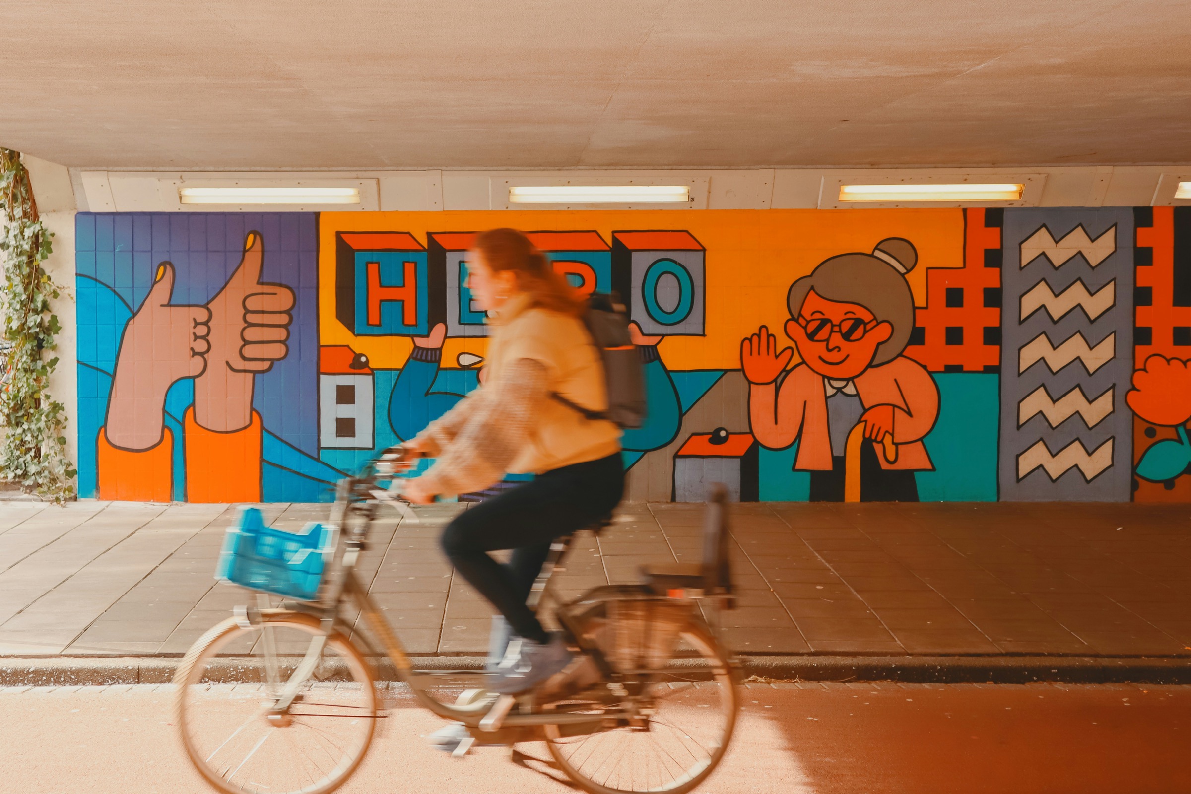 Fietser in een tunnel met een kleurrijke muurschildering in Eindhoven
